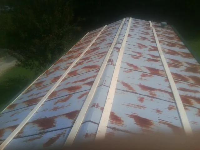 Rusted metal roof panels with new wood purlins before replacement — Storm Damage Roof Repair in Collegeport by Roofing Brothers