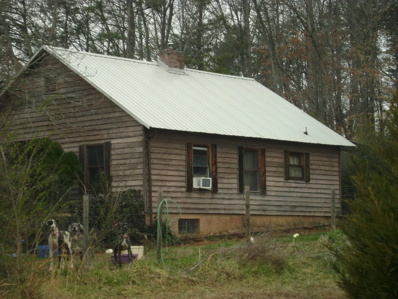 White metal roof on an old wood sided farmhouse, from a Metal Roof Installation job in Collegeport